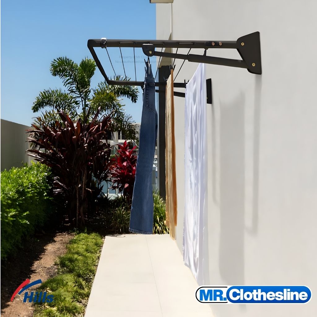 Hills Compact Fold Down Clothesline installed outside in Monument colour with washing hanging on the drying lines.