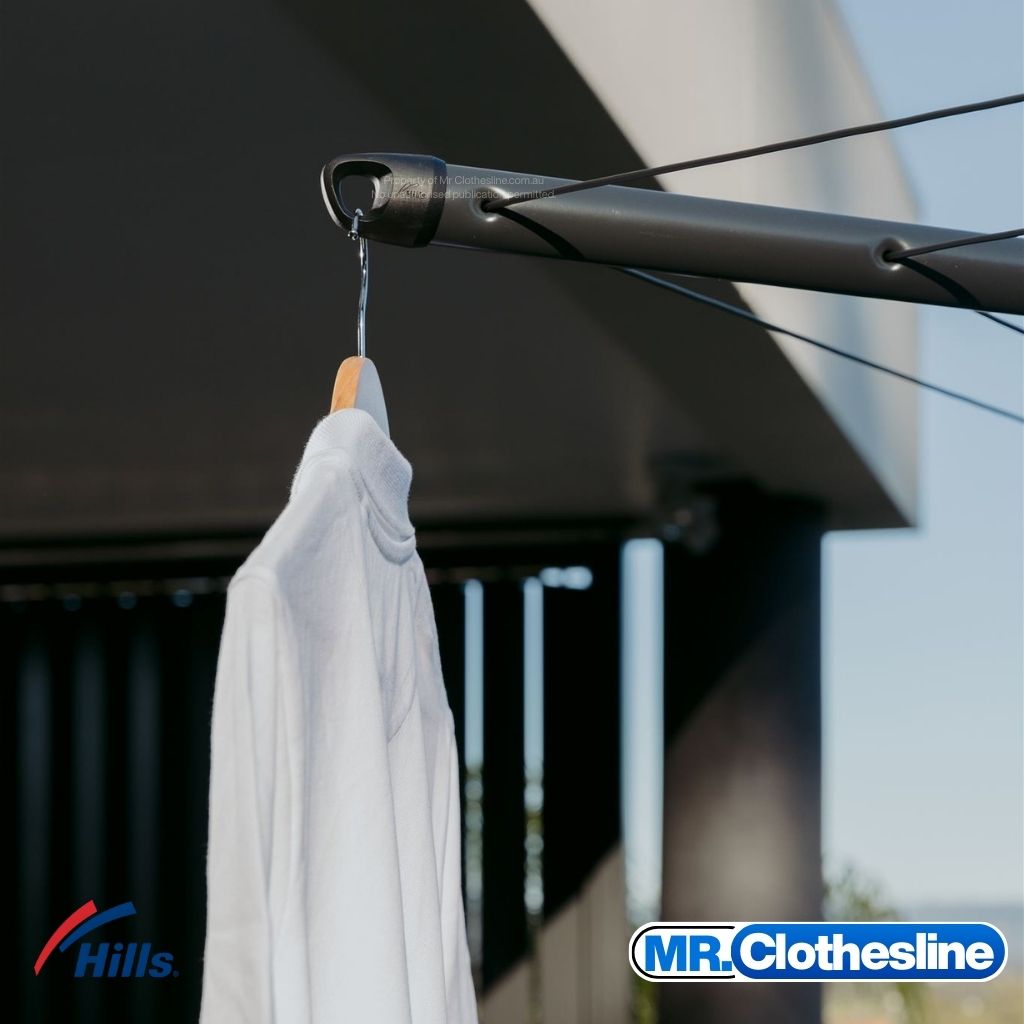 Hills Folding Rotary 6-Line Clothesline arm tip coathanger hook in Monument colour with white shirt hanging on wooden hanger.