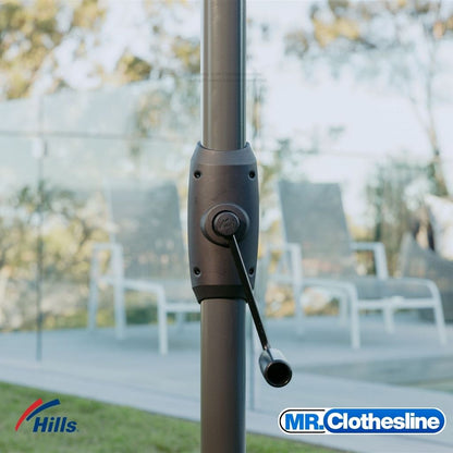 Hills Folding Rotary 8-Line Clothesline winder handle detail in Monument colour outdoors beside pool, used to raise and lower the rotary head.
