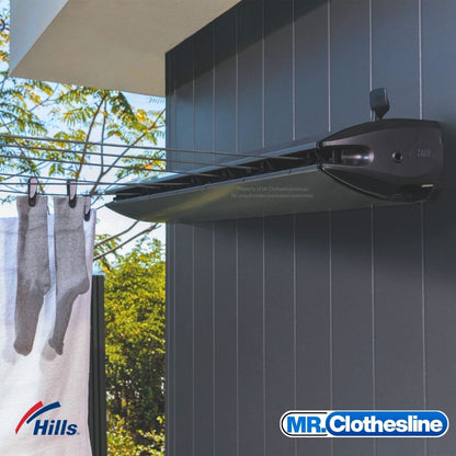 Hills Retractable 5-Line Clothesline installed on a dark wall with washing on the lines