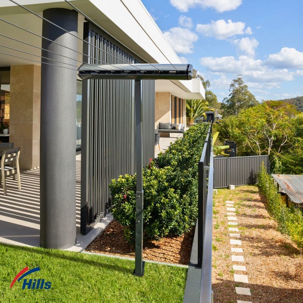 Hills Retractable 7-Line Clothesline lifestyle installed in backyard with lines extended.